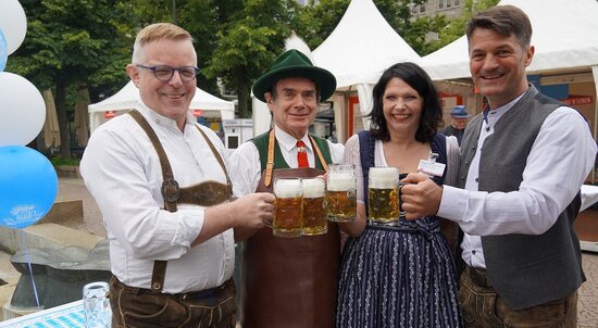 ©RTG Gruppe von Menschen in Tracht, die mit Bier anstoßen